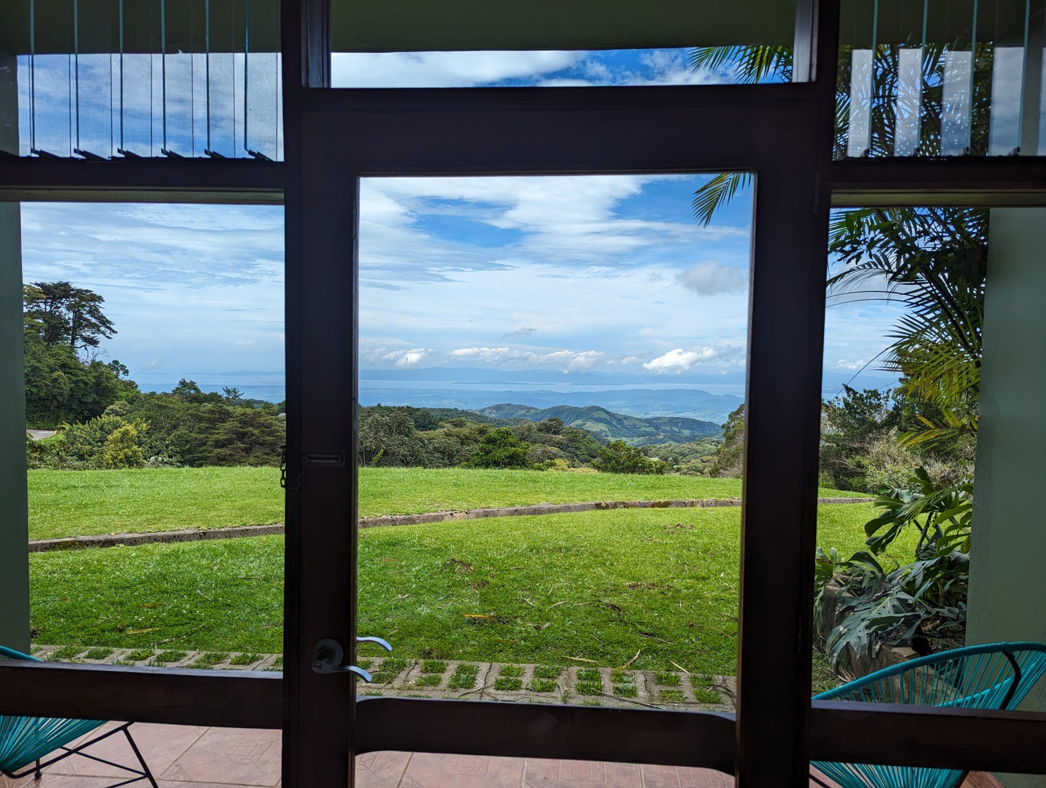 Sweeping view of the Pacific Ocean with green fields, from hotel in Monteverde