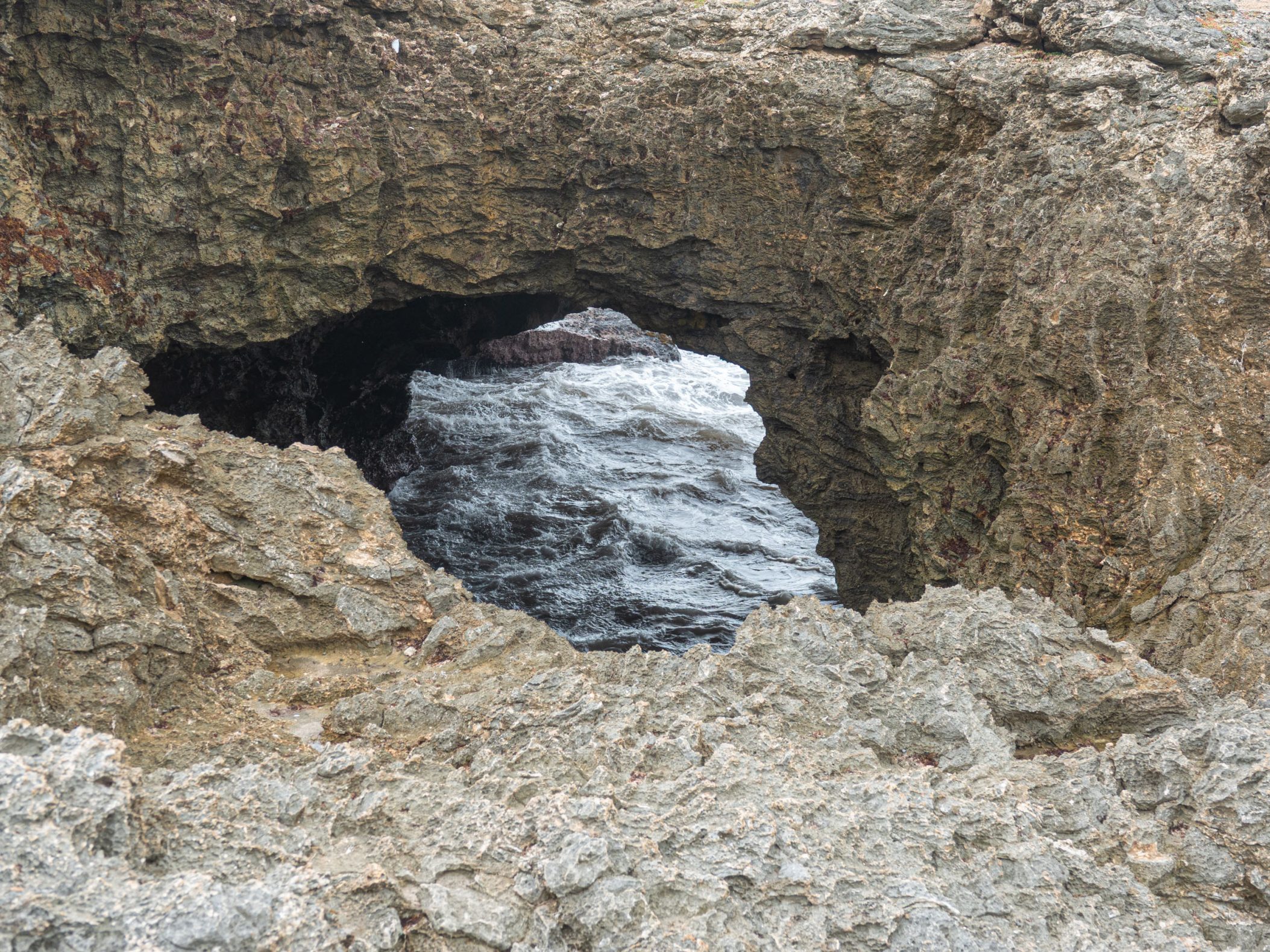 Oceanside cliffs with an opening in the middle of ocean
