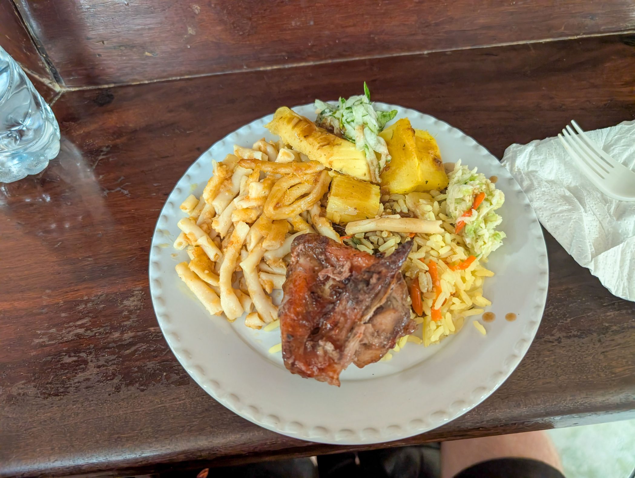 Plate of food with chicken, macaroni pie, and several others